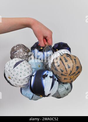 Une collection de boules en papier faites à la main maintenues ensemble sur un fond blanc Banque D'Images
