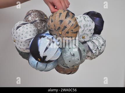 Une collection de boules en papier faites à la main maintenues ensemble sur un fond blanc Banque D'Images