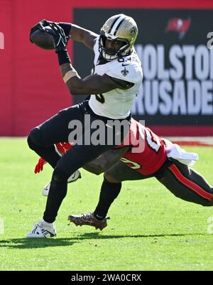 Tampa, États-Unis. 31 décembre 2023. New Orleans Saints Tight End Juwan Johnson (83) passe-bas un palan de Tampa Bay Buccaneers safety Christian Izien (29) lors de la première mi-temps au Raymond James Stadium à Tampa, Floride, le dimanche 31 décembre 2023. Photo de Steve Nesius/UPI. Crédit : UPI/Alamy Live News Banque D'Images