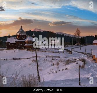 Petit village alpin calme et lever de soleil d'hiver montagne enneigée autour, Voronenko, Carpates, Ukraine. Banque D'Images