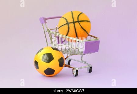 Le basket-ball et le soccer ball orange dans votre panier sur violet. Le concept de vente d'équipement de sport, de prévisions pour des matchs de sport, paris sportifs Banque D'Images