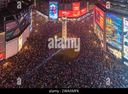 CHONGQING, CHINE - 31 DÉCEMBRE 2023 - Un grand nombre de personnes se rassemblent sous le monument Jiefang pour écouter la cloche du nouvel an et libérer Wish bal Banque D'Images