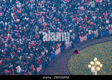 CHONGQING, CHINE - 31 DÉCEMBRE 2023 - Un grand nombre de personnes se rassemblent sous le monument Jiefang pour écouter la cloche du nouvel an et libérer Wish bal Banque D'Images