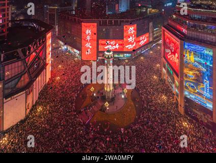 CHONGQING, CHINE - 31 DÉCEMBRE 2023 - Un grand nombre de personnes se rassemblent sous le monument Jiefang pour écouter la cloche du nouvel an et libérer Wish bal Banque D'Images