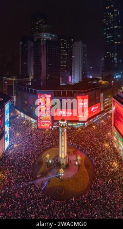 CHONGQING, CHINE - 31 DÉCEMBRE 2023 - Un grand nombre de personnes se rassemblent sous le monument Jiefang pour écouter la cloche du nouvel an et libérer Wish bal Banque D'Images