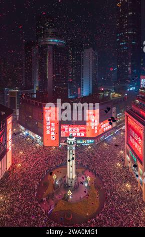 CHONGQING, CHINE - 31 DÉCEMBRE 2023 - Un grand nombre de personnes se rassemblent sous le monument Jiefang pour écouter la cloche du nouvel an et libérer Wish bal Banque D'Images