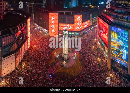 CHONGQING, CHINE - 31 DÉCEMBRE 2023 - Un grand nombre de personnes se rassemblent sous le monument Jiefang pour écouter la cloche du nouvel an et libérer Wish bal Banque D'Images