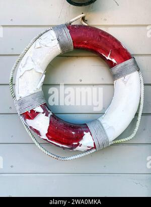 Un anneau de sauvetage rouge et blanc, un sauveteur ou un gilet de sauvetage accroché à un mur près de la plage en été Banque D'Images