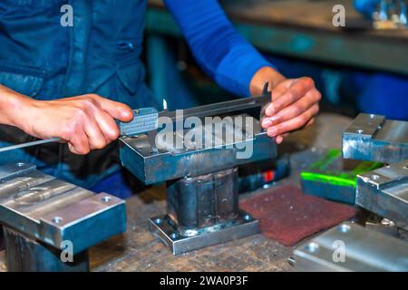 Opérateur avec un doigt coupé travaillant dans une entreprise avec fraises dans un atelier de commande numérique, haute technologie grâce à un centre d'usinage CNC. Banque D'Images