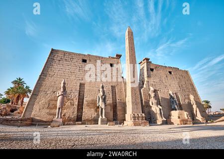 Louxor, Égypte - décembre 26 2023 : entrée principale du temple de Louxor, premier pylône avec obélisque et statues de Ramsès II Banque D'Images