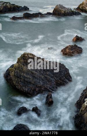 Rochers côtiers et mer dans le vent. Portknockie, Morayshire, Écosse. exposition longue Banque D'Images