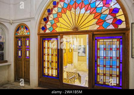 Chambre avec vitraux colorés dans la maison Taj, manoir historique du 19e siècle à Kashan, Iran. Banque D'Images