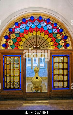 Chambre avec vitraux colorés dans la maison Taj, manoir historique du 19e siècle à Kashan, Iran. Banque D'Images