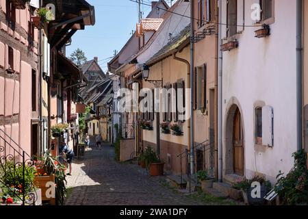 Rue aux maisons pittoresques dans le village médiéval d'Eguisheim, sur la route des vins d'Alsace Banque D'Images