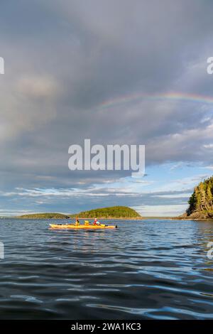 Une femme et sa fille font du kayak de mer sous un arc-en-ciel dans la baie Frenchman, parc national Acadia, Maine. Îles Porcupine. Banque D'Images