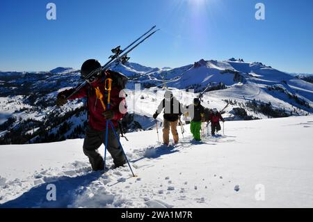 Quatre skieurs marchent sur une crête dans une station de montagne près de South Lake Tahoe, en Californie. Banque D'Images