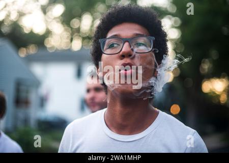 Jeune homme exhalant un panache de smole Banque D'Images