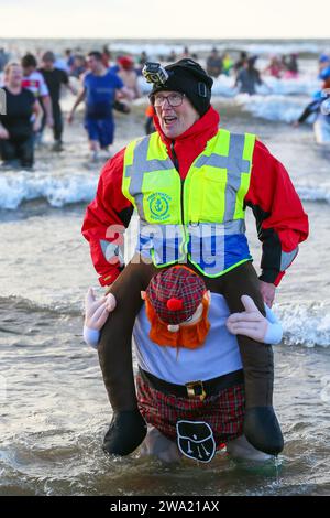 Irvine, Ayrshire, Royaume-Uni. 01 Jan 24. Irvine, Royaume-Uni. Plusieurs centaines de personnes ont pris part à la fête annuelle Polar Plunge du jour de l'an de Irvine Beach, Ayrshire, dans le Firth of Clyde. Beaucoup de nageurs collectaient des fonds pour l'association Credit : Findlay/Alamy Live News Banque D'Images