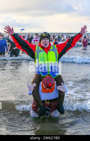 Irvine, Ayrshire, Royaume-Uni. 01 Jan 24. Irvine, Royaume-Uni. Plusieurs centaines de personnes ont pris part à la fête annuelle Polar Plunge du jour de l'an de Irvine Beach, Ayrshire, dans le Firth of Clyde. Beaucoup de nageurs collectaient des fonds pour l'association Credit : Findlay/Alamy Live News Banque D'Images