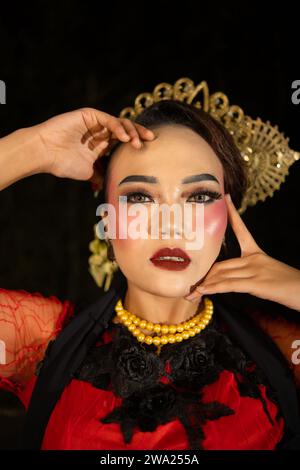 Une danseuse sundanaise portant des bijoux en or qui donne une sensation luxueuse à son apparence sur scène la nuit Banque D'Images