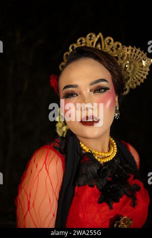 Une danseuse sundanaise portant des bijoux en or qui donne une sensation luxueuse à son apparence sur scène la nuit Banque D'Images