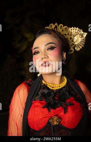 Une danseuse sundanaise portant des bijoux en or qui donne une sensation luxueuse à son apparence sur scène la nuit Banque D'Images