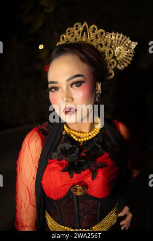 Une danseuse sundanaise portant des bijoux en or qui donne une sensation luxueuse à son apparence sur scène la nuit Banque D'Images