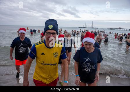 Prerow, Allemagne. 01 janvier 2024. Les nageurs amateurs émergent des eaux à 5 degrés de la mer Baltique. Des centaines de vacanciers de nombreux États allemands ont une fois de plus participé à la traditionnelle baignade du nouvel an sur la péninsule de Fischland-Darß-Zingst. Crédit : Stephan Schulz/dpa/Alamy Live News Banque D'Images