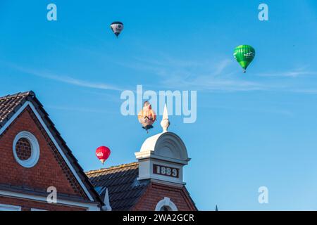Bunte Heißluftballons über den Dächern der Kieler Altstadt vor blauem Himmel im Sommer Banque D'Images