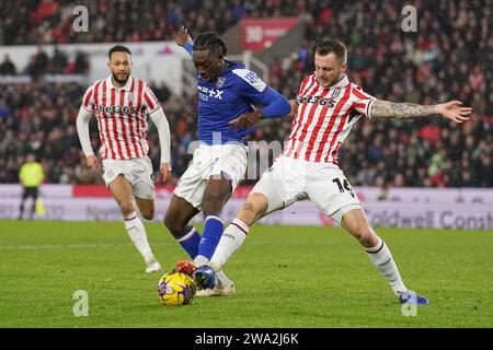 Freddie Ladapo d'Ipswich Town (au centre) et Ben Wilmot de Stoke City (à droite) se battent pour le ballon lors du Sky Bet Championship Match au Bet365 Stadium, Stoke-on-Trent. Date de la photo : lundi 1 janvier 2024. Banque D'Images