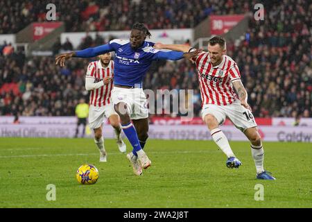 Freddie Ladapo d'Ipswich Town (au centre) et Ben Wilmot de Stoke City (à droite) se battent pour le ballon lors du Sky Bet Championship Match au Bet365 Stadium, Stoke-on-Trent. Date de la photo : lundi 1 janvier 2024. Banque D'Images