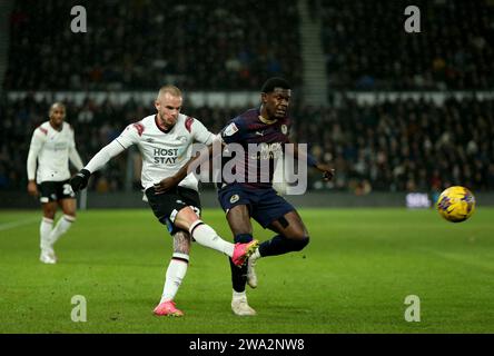 Joe Ward du comté de Derby (à gauche) et Ephron Mason-Clark de Peterborough United se battent pour le ballon lors du match de Sky Bet League One au Pride Park, Derby. Date de la photo : lundi 1 janvier 2024. Banque D'Images