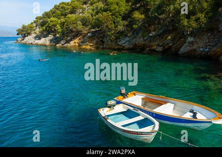 Deux petits bateaux de pêche flottent sur les eaux claires de la côte de Fethiye en Turquie Banque D'Images