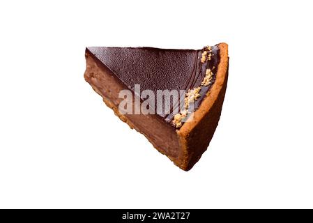 Délicieux gâteau au chocolat frais et sucré avec des noix coupées en tranches sur un fond de béton foncé Banque D'Images