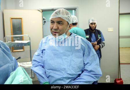 Khan Yunis, Gaza. 31 décembre 2023. Le chirurgien américain Imad se prépare à opérer un patient dans une salle d’opération chirurgicale de l’hôpital européen de Khan Yunis, dans le sud de la bande de Gaza, le lundi 1 janvier 2024. Le chirurgien Imad, accompagné d’un groupe de médecins, est arrivé à Gaza depuis le poste frontière de Rafah avec l’Égypte, pour effectuer des opérations chirurgicales sur les Palestiniens blessés pendant la guerre. Photo par Ismael Mohamad/UPI crédit : UPI/Alamy Live News Banque D'Images