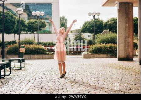 Belle petite fille dansant sous la pluie, portant une robe de ballerine douce Banque D'Images