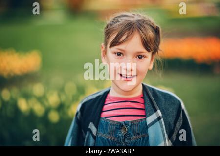 Portrait d'été de jeune fille heureuse portant des combinaisons en denim Banque D'Images