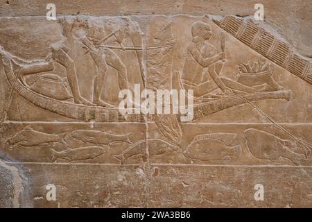 Saqqara, Égypte - 2 janvier 2024 : personnages en bas relief peints montrant la vie quotidienne dans l'Égypte ancienne à l'intérieur de la tombe de Kagemni dans la nécropole de Saqqara Banque D'Images