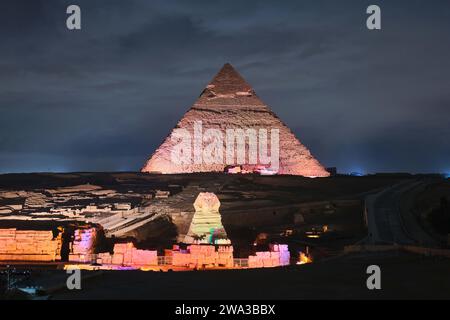 Gizeh, Egypte - décembre 24 2023 : Sphinx et Pyramide de Khafre (Kefren) sur le plateau de Gizeh, le Caire aux lumières de la nuit Banque D'Images