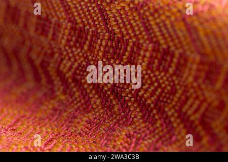 tissu tissé de sergé variés tissés dans des couleurs rouge vif et orange, macro plan détaillé avec une faible profondeur de champ Banque D'Images