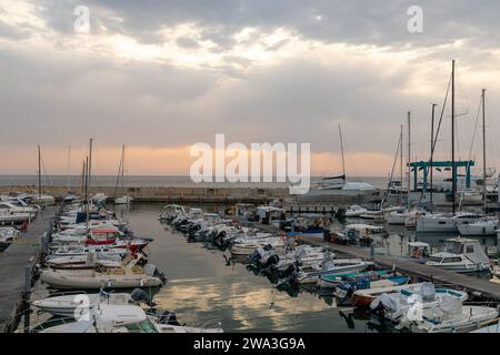 Vue sur le port touristique sur la côte étrusque avec voiliers amarrés et yachts au coucher du soleil, San Vincenzo, Livourne, Toscane, Italie Banque D'Images