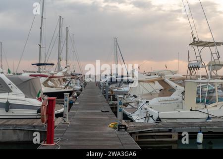 Vue sur le port touristique sur la côte étrusque avec voiliers amarrés et yachts au coucher du soleil, San Vincenzo, Livourne, Toscane, Italie Banque D'Images