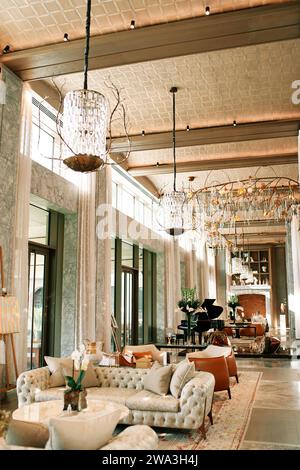 Hall d'entrée de luxe avec canapés, tables et lustres élégants au plafond Banque D'Images