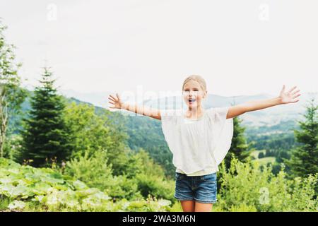 Petite fille de gamin randonnant dans les montagnes, les bras grands ouverts. Image prise dans le canton de Vaud, Suisse Banque D'Images