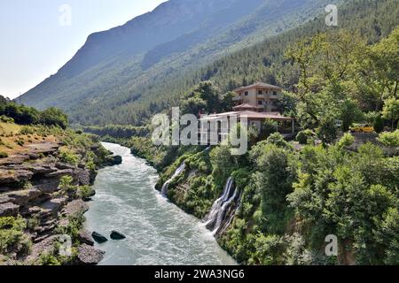 Un restaurant avec terrasse est situé entre deux cascades directement sur la rivière Vjosa, Kelcyre gorge, Kelcyre, Albanie, Europe Banque D'Images