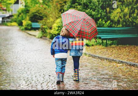 Deux enfants sous un parasol, vue arrière Banque D'Images