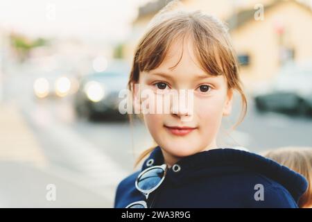 Portrait en gros plan candide d'une jeune fille de 9 ans marchant à côté de la route Banque D'Images