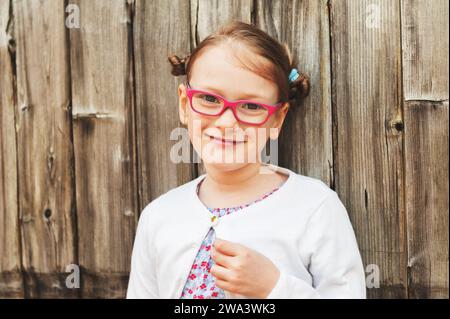 Portrait en plein air d'une mignonne petite fille portant des lunettes Banque D'Images