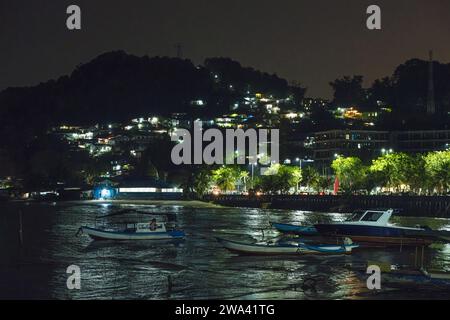 Bateaux de pêcheurs reposant sur le rivage dans la nuit. et il y a quelques villages de pêcheurs empilés sur la colline. Banque D'Images