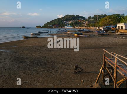 Bateaux de pêcheurs reposant sur le rivage dans l'après-midi. il y a un phare au sommet de la colline. Banque D'Images